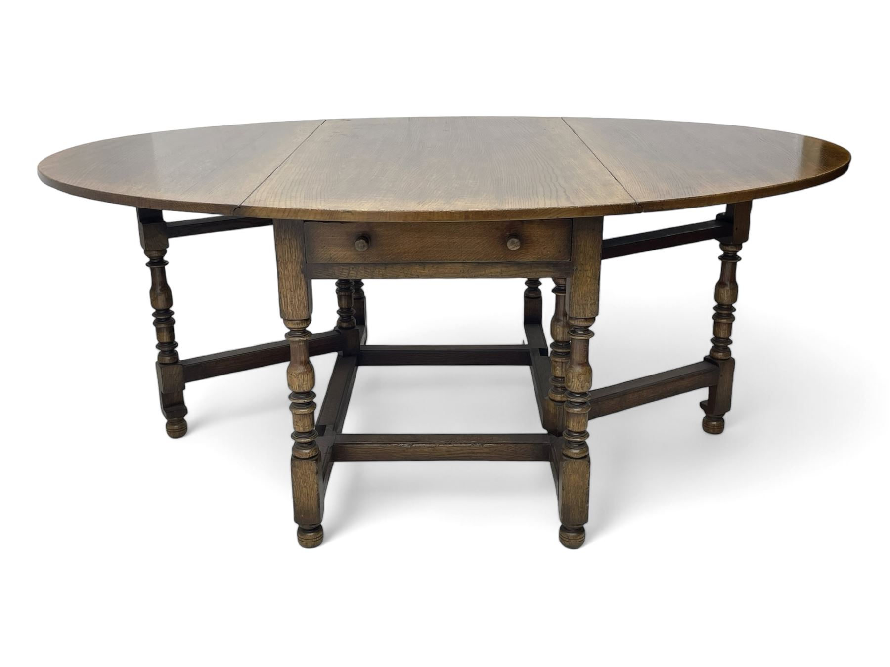 Titchmarsh & Goodwin - 17th century design oak drop leaf dining table, oval top with hinged drop leaves, single drawer to one side with applied makers label, baluster-turned supports united by stretchers