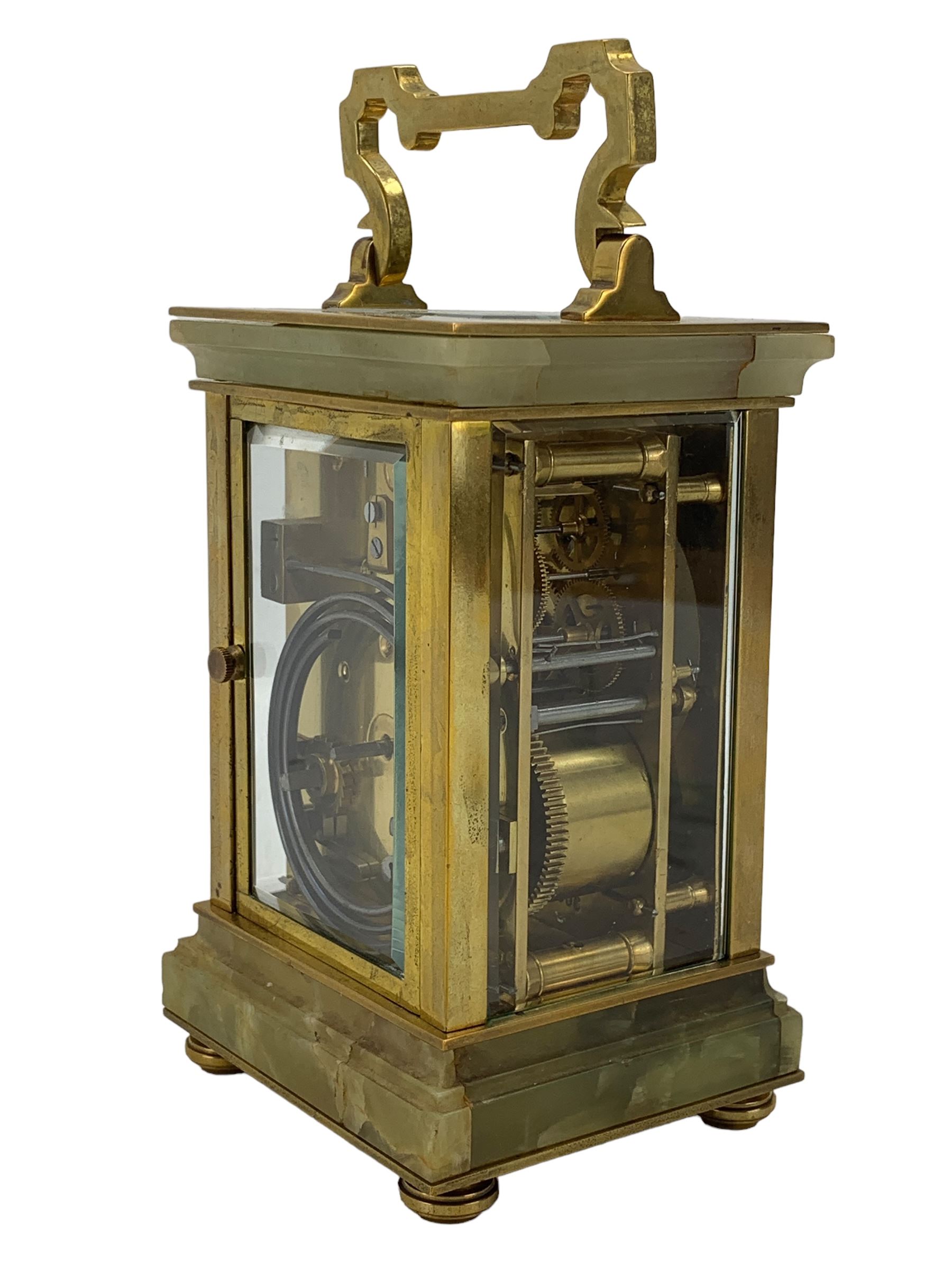 French - early 20th century two train carriage clock, in an onyx serpentine case raised on bun feet, with four bevelled panels and rectangular escapement viewing panel, white enamel dial with Roman numerals and steel spade hands, 8-day movement with a jewelled lever platform escapement and rack striking, sounding the hours and half hours on a coiled gong. With key.