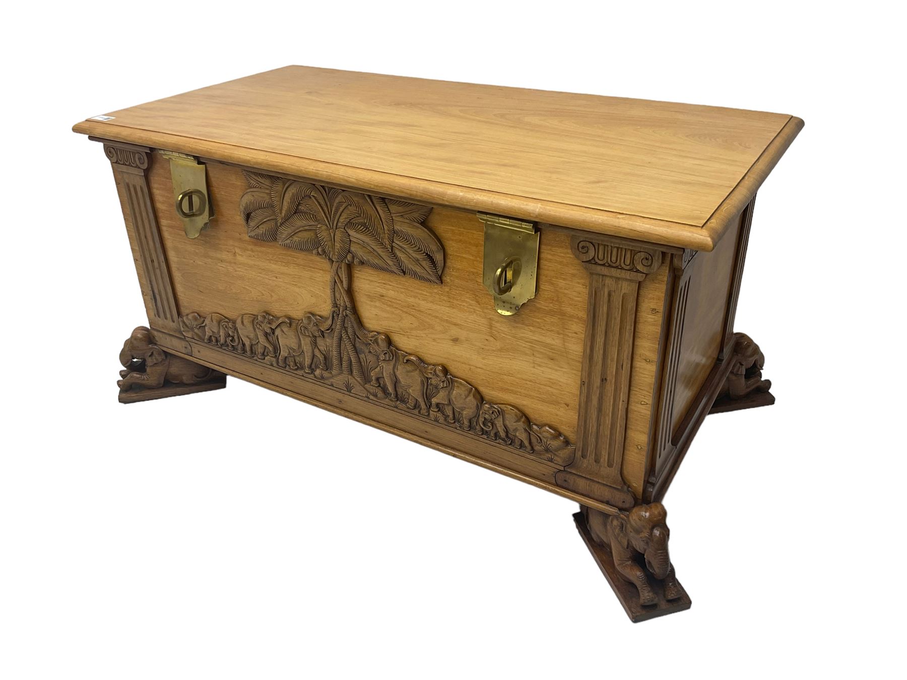 India camphor wood blanket box, moulded hinged lid, decorated with carved elephants and trees, on elephant carved feet