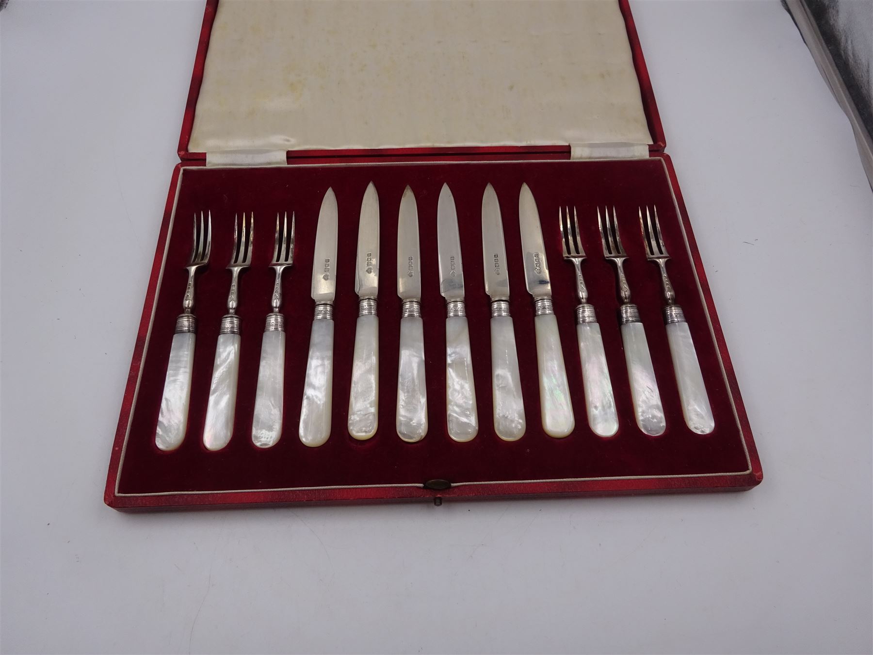 Set of six 1920s silver dessert knife and forks for six place settings, with mother of pearl handles, hallmarked Goldsmiths & Silversmiths Co Ltd, London 1920, contained within fitted case