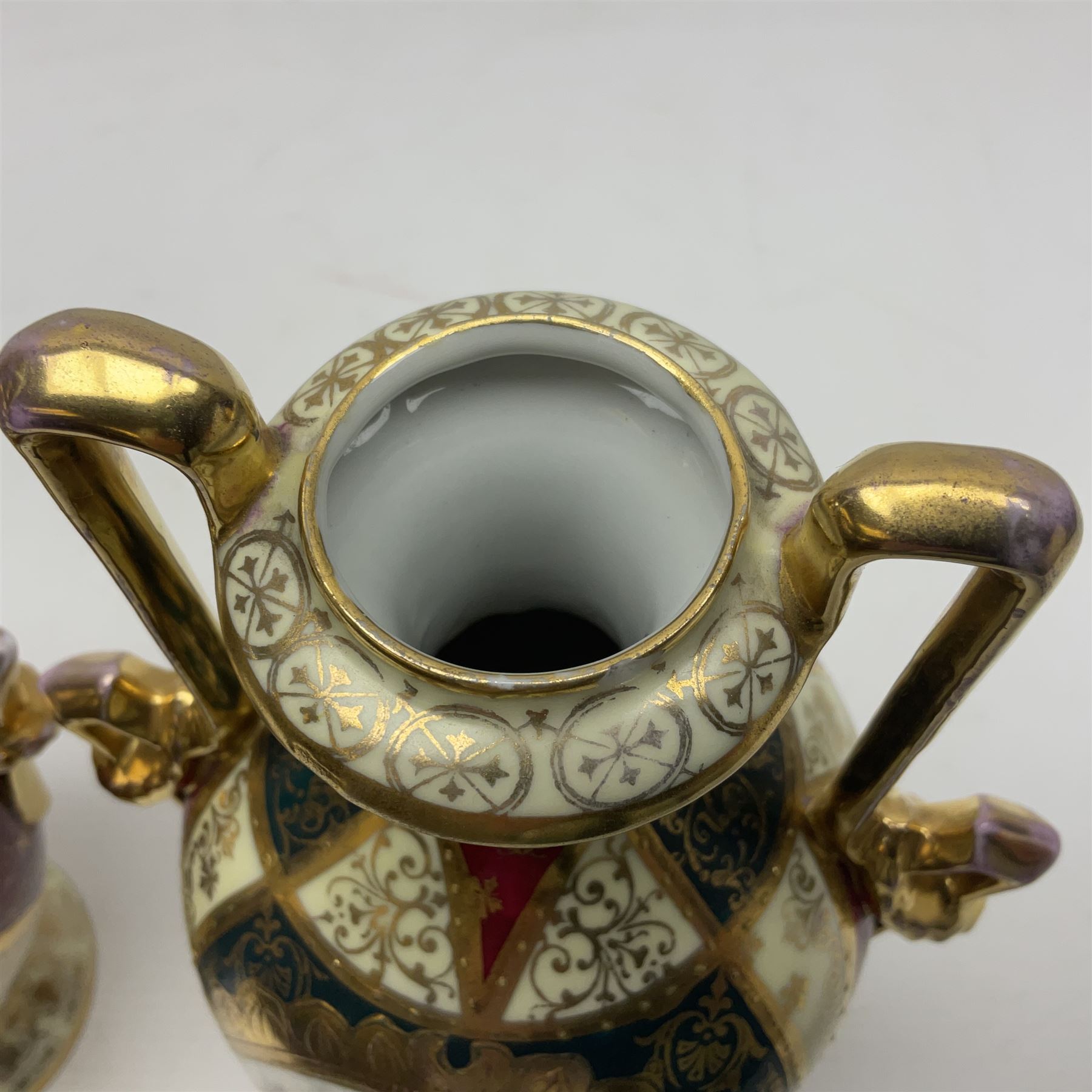 Pair of Vienna style twin handled urns and covers, decorated with figural scene on green, red and white ground with gilt highlights, stamped with beehive mark beneath, H25cm