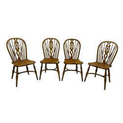 Set of four elm Windsor dining chairs, hoop and stick back with shaped wheel splat, dished seat on turned supports united by crinoline stretcher 