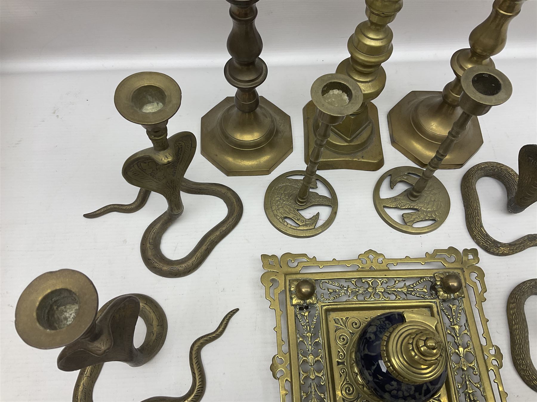 Brass inkstand, of square form, pierced, inset with blue and white ceramic inkwell to centre, together with a collation of brass candlesticks 