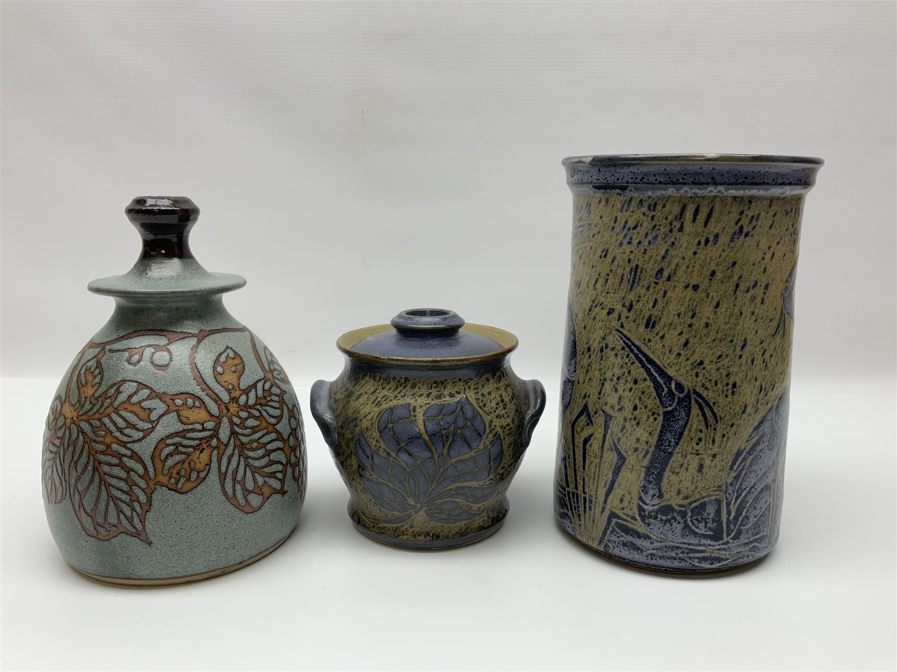 John Egerton (c1945-): studio pottery stoneware, comprising wine cooler decorated with herons on a mottled ground, covered storage jar with foliage decoration and a lamp base decorated with grape vines, wine cooler H23cm