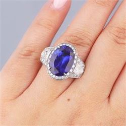 Platinum tanzanite and diamond ring, oval cut tanzanite, with round brilliant cut diamond surround, each side flanked by a single bullet cut diamond, with round brilliant cut diamond surround, hallmarked, tanzanite 9.16 carat, bullet cut diamonds 0.95 carat, round brilliant cut diamonds 0.83 carat