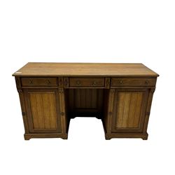 Late Victorian oak twin pedestal desk, chamfered rectangular top over three convex front edge drawers and two panelled cupboards, flanked by carved supports with roundels and diamond motif, on bracketed plinth base