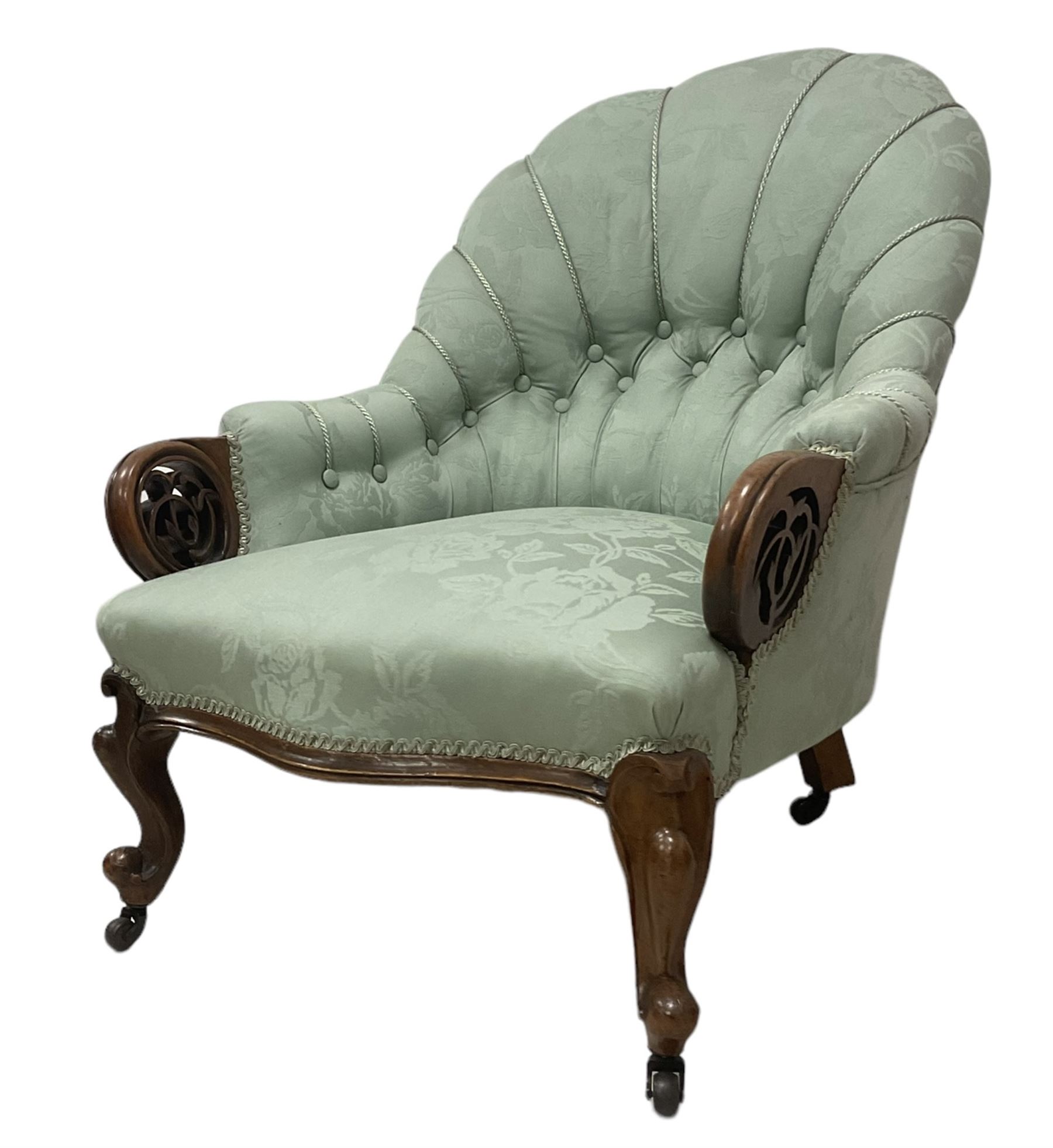 19th century mahogany framed fan-back armchair, upholstered in buttoned turquoise floral damask fabric with spring seat and pearlescent piping, pierced and carved arm terminals with floral motif, over serpentine fronted seat, raised on cartouche carved cabriole supports with castors