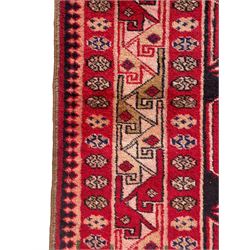 Persian Hamadan indigo and crimson ground rug, the field filled with three shaped medallions, overall geometric design, decorated with sandikli and hac motifs, geometric main border with repeating hooked motifs, within guard stripes decorated with small flower heads, outer crenelated fence band 