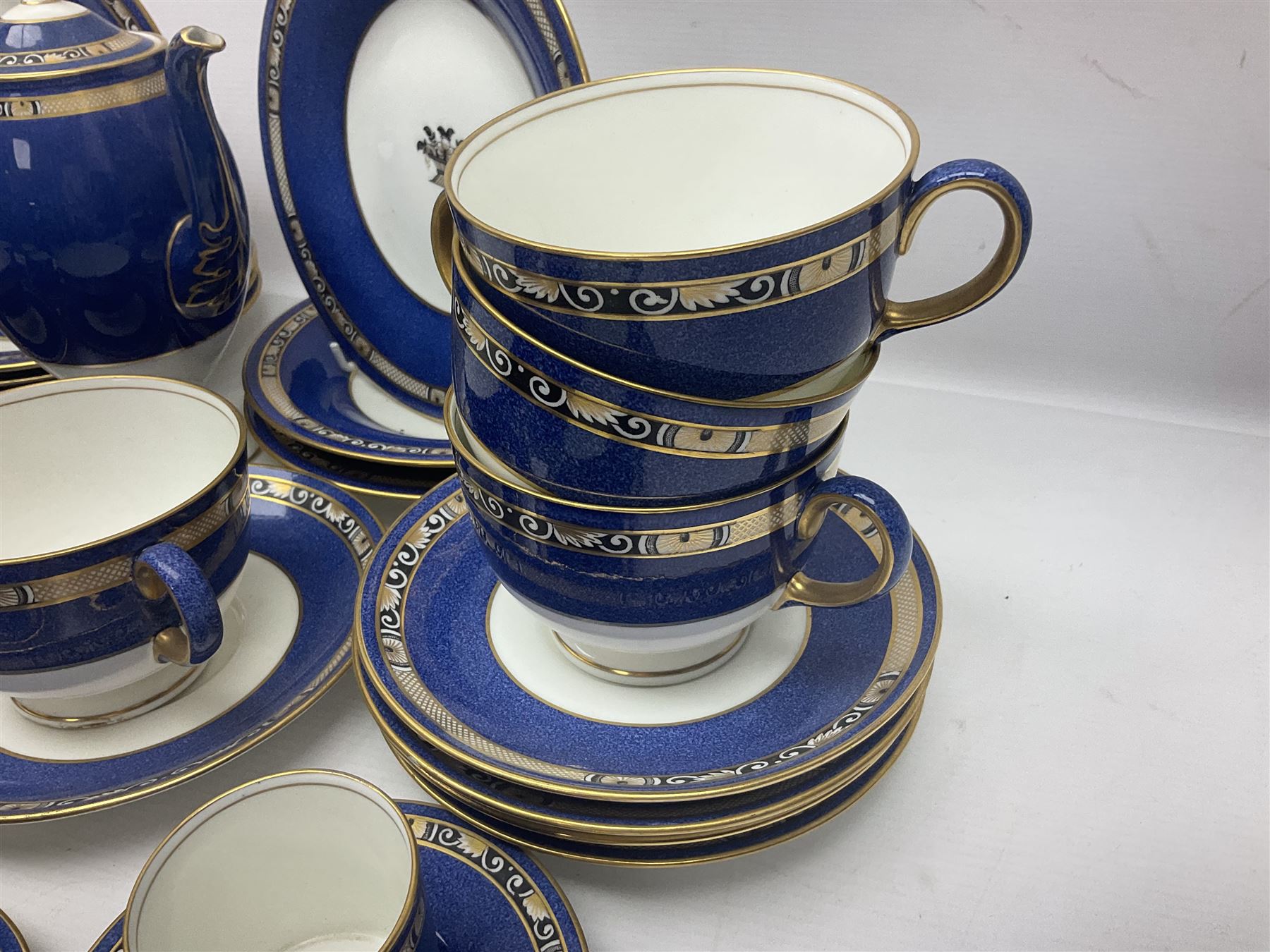 Wedgwood part tea and coffee service, comprising coffee pot, six coffee cans with five saucers, seven teacups with ten saucers and seven side plates, each decorated with floral bouquet to centre, in a gilt and speckled blue border, pattern x9933, with printed mark beneath