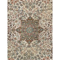 Large Persian design carpet, overall floral design, the field decorated with large rosette motifs surrounded by trailing foliate motifs, the border decorated with trailing branch and stylised plant motifs