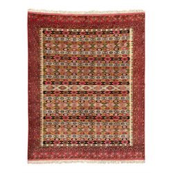 Persian red ground rug, the field divided into horizontal rows and decorated with geometri...