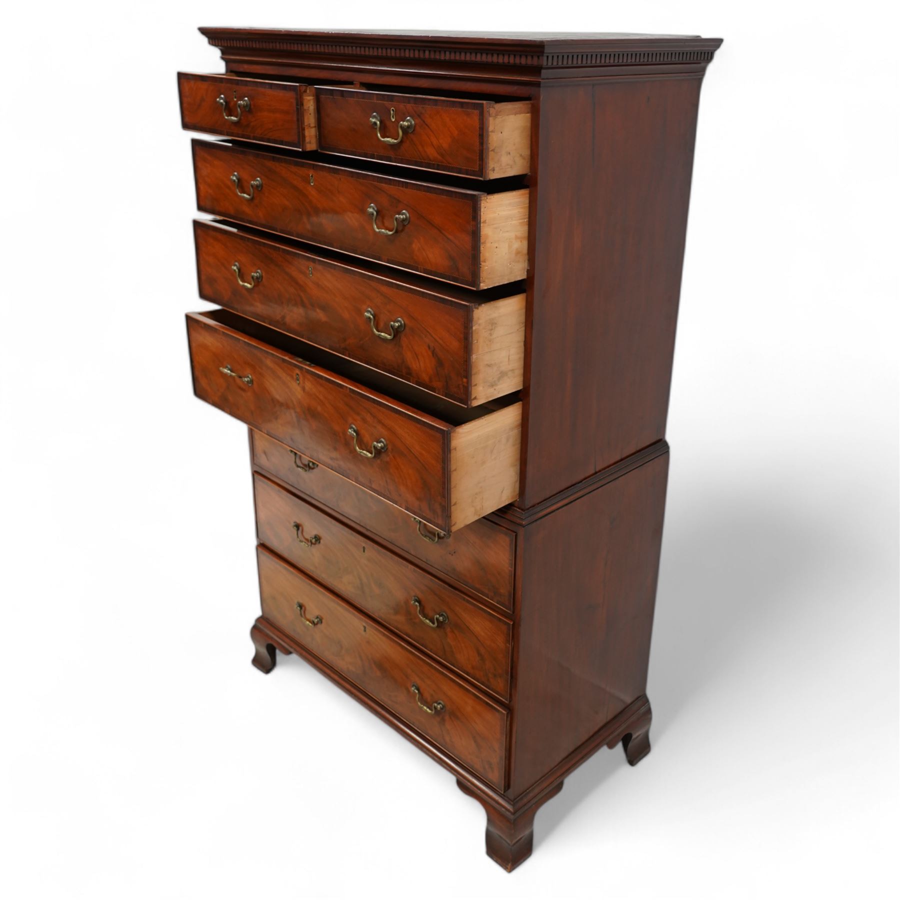 George III mahogany chest-on-chest, projecting moulded and dentil cornice, fitted with two short over six long graduating cock-beaded drawers, each with mahogany band and checkered stringing, brass swan neck handles and circular plates, on ogee bracket feet