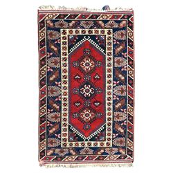 Turkish crimson ground rug, the field decorated with three geometric medallions within a band of star motifs, the main border decorated with stylised plant motifs 