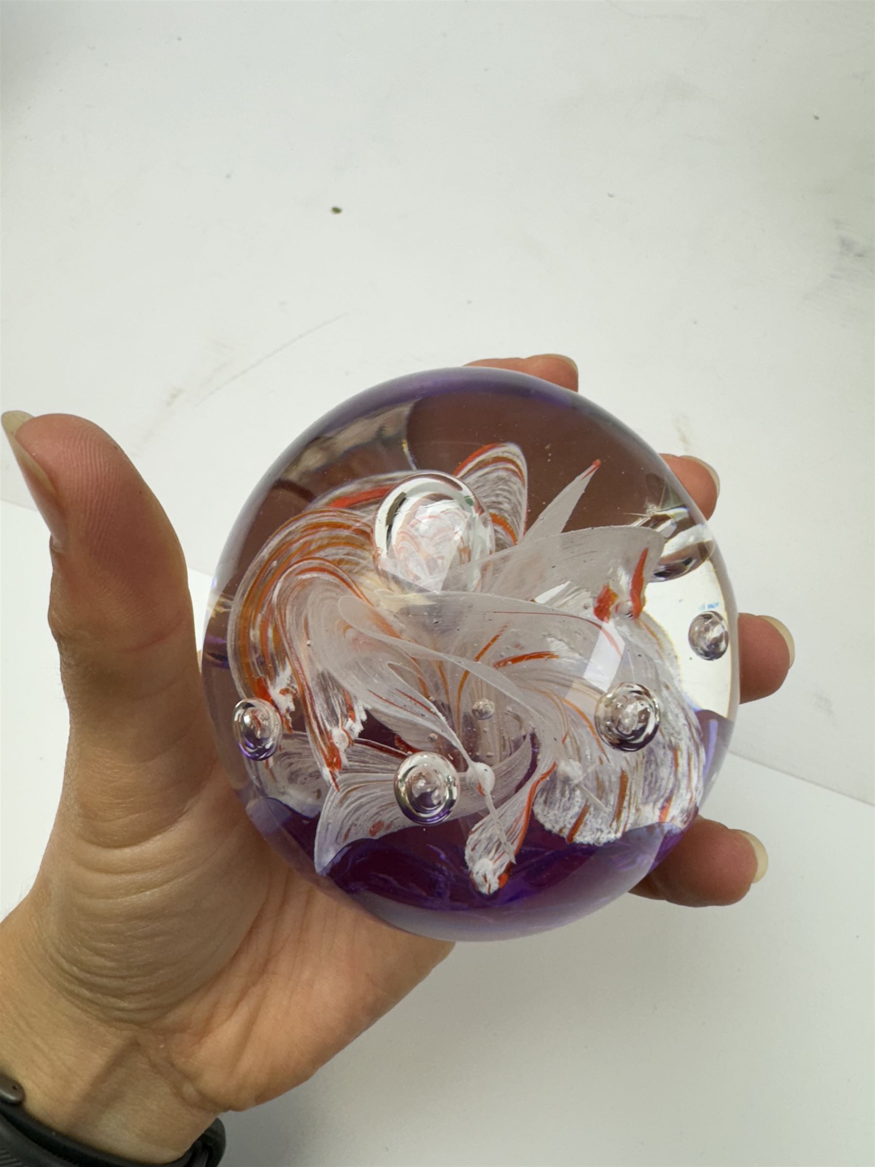 Two glass dump paperweights, with flower inclusions, together with four further glass paperweights