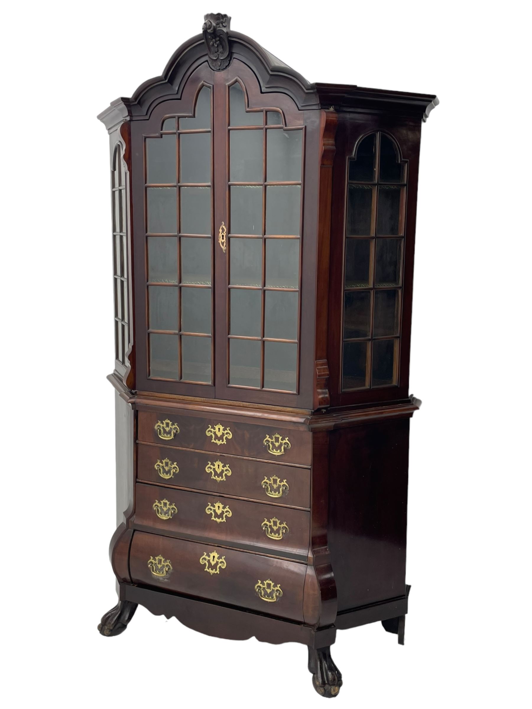 19th century Dutch mahogany vitrine on chest, shaped moulded pediment with central C-scroll and flowerhead carved mount, enclosed by two astragal glazed doors, the interior fitted with fabric lined shelves, four graduating long drawers below, on ball and claw carved feet 