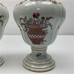 Pair of pot pourri vases and covers, decorated with floral sprigs and with rose finials to the covers, H24cm