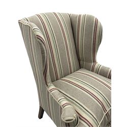 Georgian design hardwood-framed wingback armchair, curved wingback terminating to curved and rolled arms, upholstered in striped fabric with loose seat cushion, on cabriole front feet 