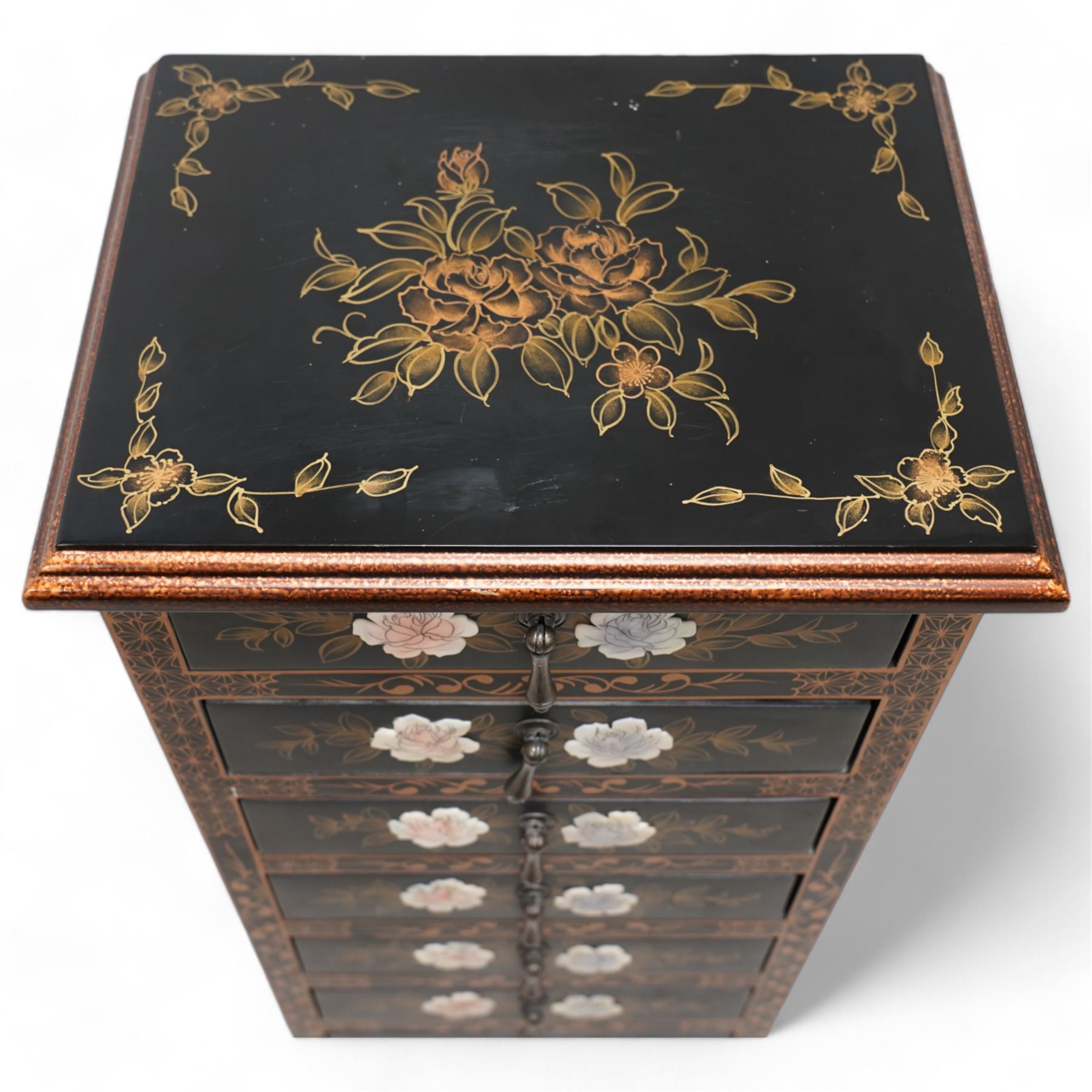 Chinoiserie decorated black lacquered pedestal chest, rectangular moulded top decorated with gilt floral patterns, fitted with eight drawers each with applied rose decoration and extending gilt foliate scrolls, on bun feet