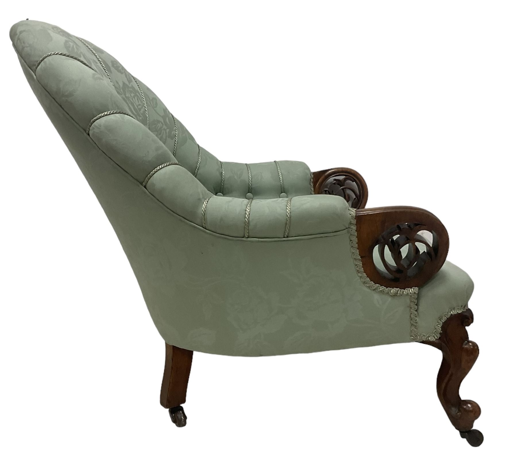 19th century mahogany framed fan-back armchair, upholstered in buttoned turquoise floral damask fabric with spring seat and pearlescent piping, pierced and carved arm terminals with floral motif, over serpentine fronted seat, raised on cartouche carved cabriole supports with castors