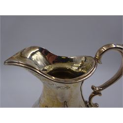 Victorian silver jug, of waisted form with C scroll handle, the body engraved with strapwork panels and circular cartouches, upon four embossed feet, hallmarked Charles Boyton, London 1864, H15.5cm