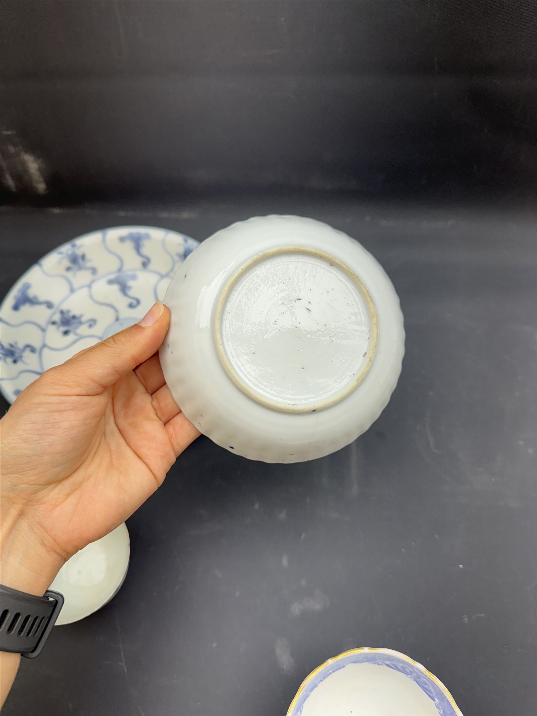 Early 19th century Chinese Tek Sing bowl, decorated with stylised blossoms, with 'Nagel Auctions' label to base, H6.5cm D15.5cm, together with a  Tek Sing similar saucer, D18cm, a Chinese tea bowl decorated in blue and red blossoming flowers, a Chinese blue and white saucer, and an English blue and white Willow pattern tea bowl, (5)