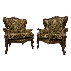 Pair of Victorian design stained beech armchairs, upholstered in leopard print fabric, with carved top rail over button-tufted backrest, scroll arms, serpentine front rail, raised on cariole supports