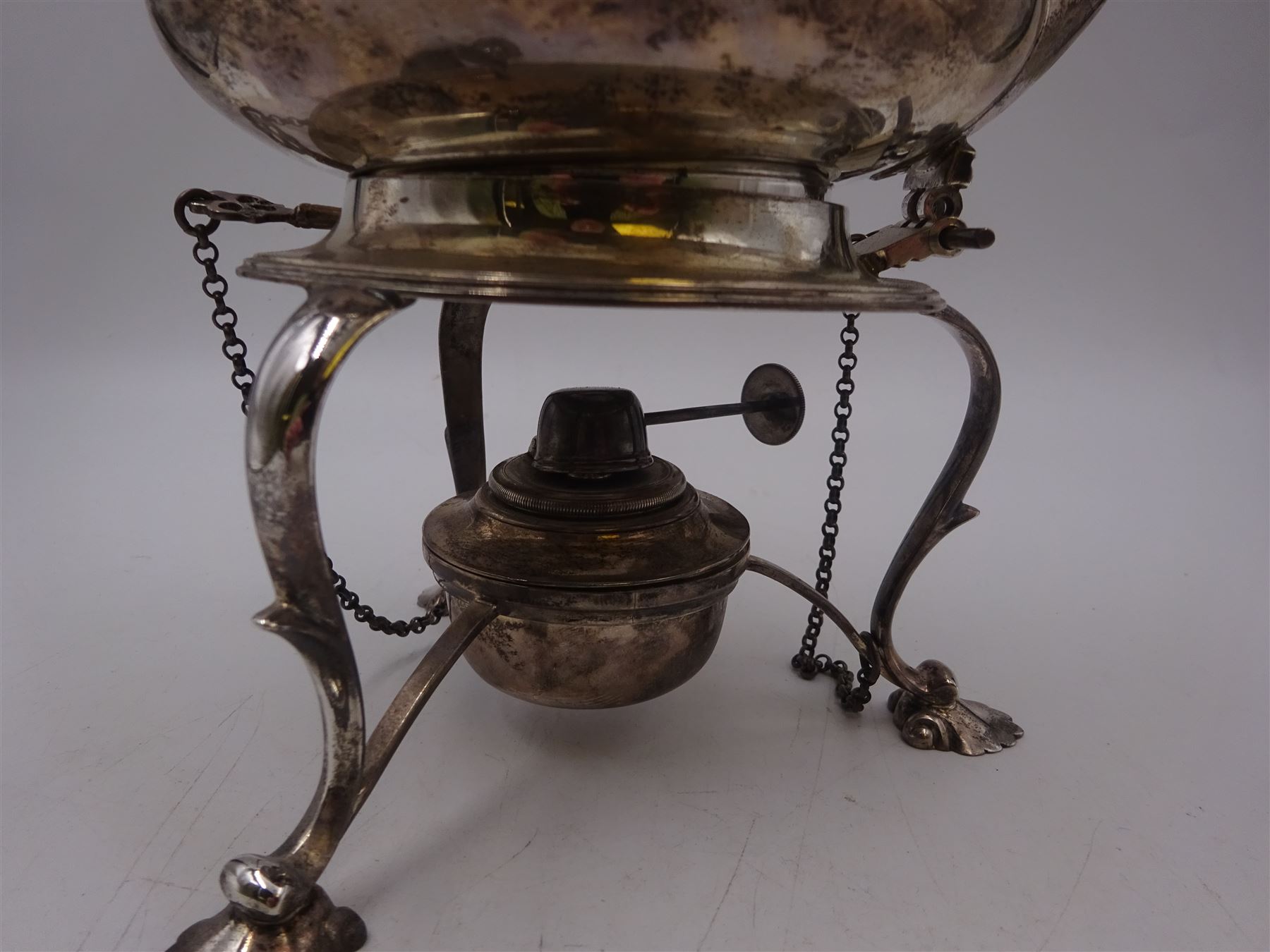 Early 20th century silver spirit kettle and burner, of oval form, with oblique gadrooned rim, engraved crest and ebonised handle and finial, the stand upon three scrolling pad feet, hallmarked Goldsmiths Silversmiths Company, London 1913, total H31cm