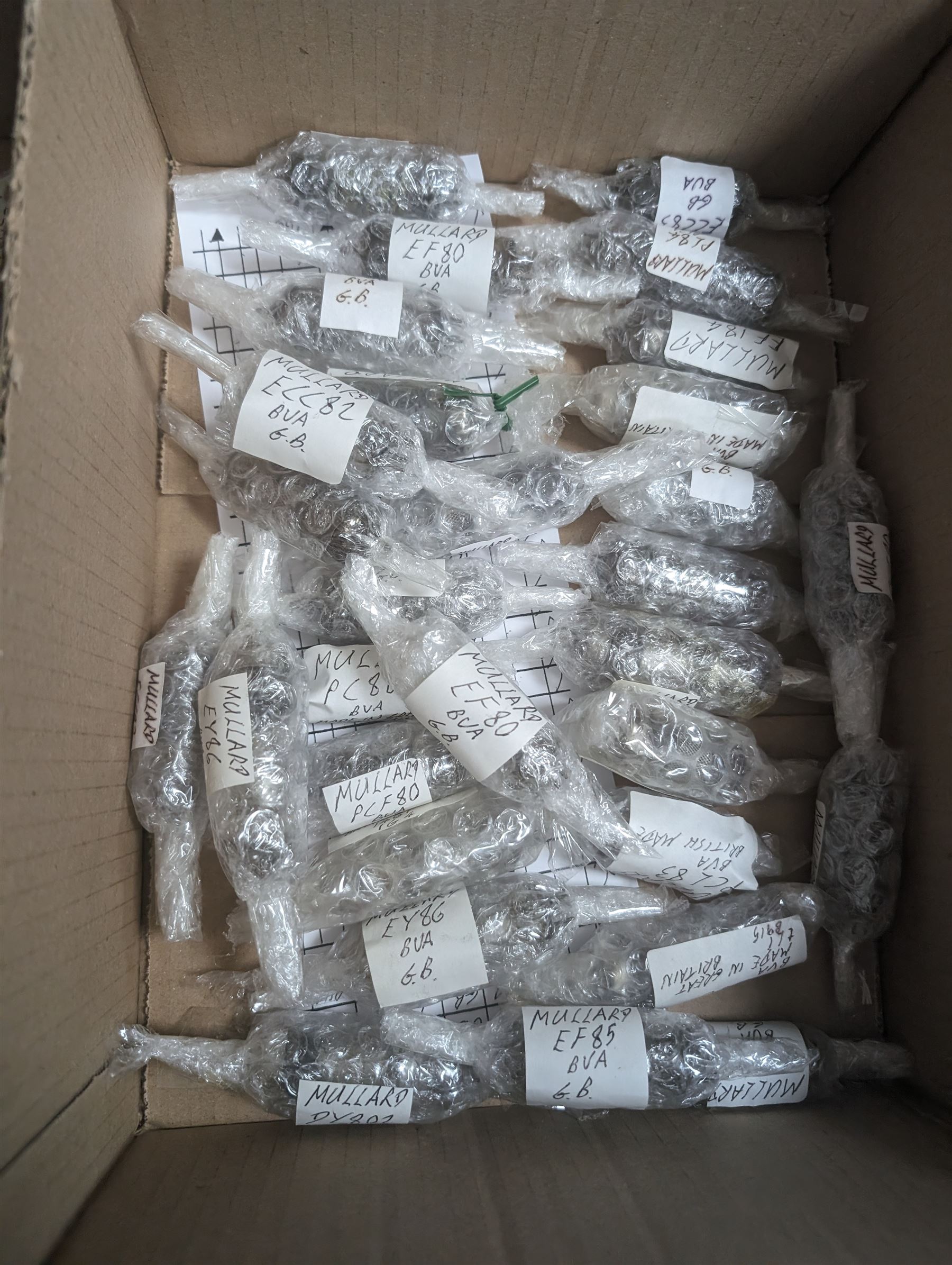 Collection of Mullard thermionic radio valves/vacuum tubes, mostly bubble wrapped and identified with lists