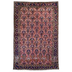 Persian Ardakan crimson ground rug, the field divided by lattice and decorated with stylis...