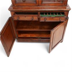 Victorian mahogany bookcase on cupboard, projecting cornice over two glazed doors, the lower section fitted with two drawers and two panelled cupboards, on moulded plinth base 