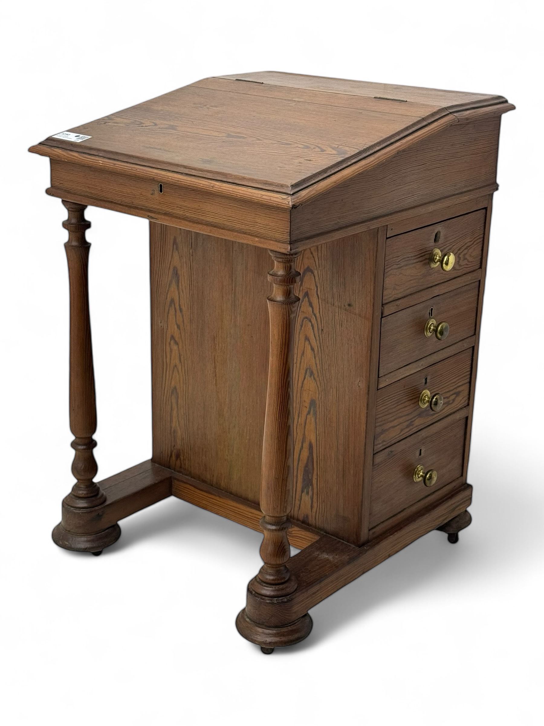 19th century pitch pine Davenport desk, sloping hinged top, fitted with four drawers, on turned column supports, turned compressed feet with castors 