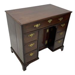 George III mahogany kneehole desk, moulded rectangular top over one long drawer, six short drawers and recessed panelled cupboard, cock-bead moulded frame, fitted with shaped brass handle plates with engraved decoration, on bracket feet 