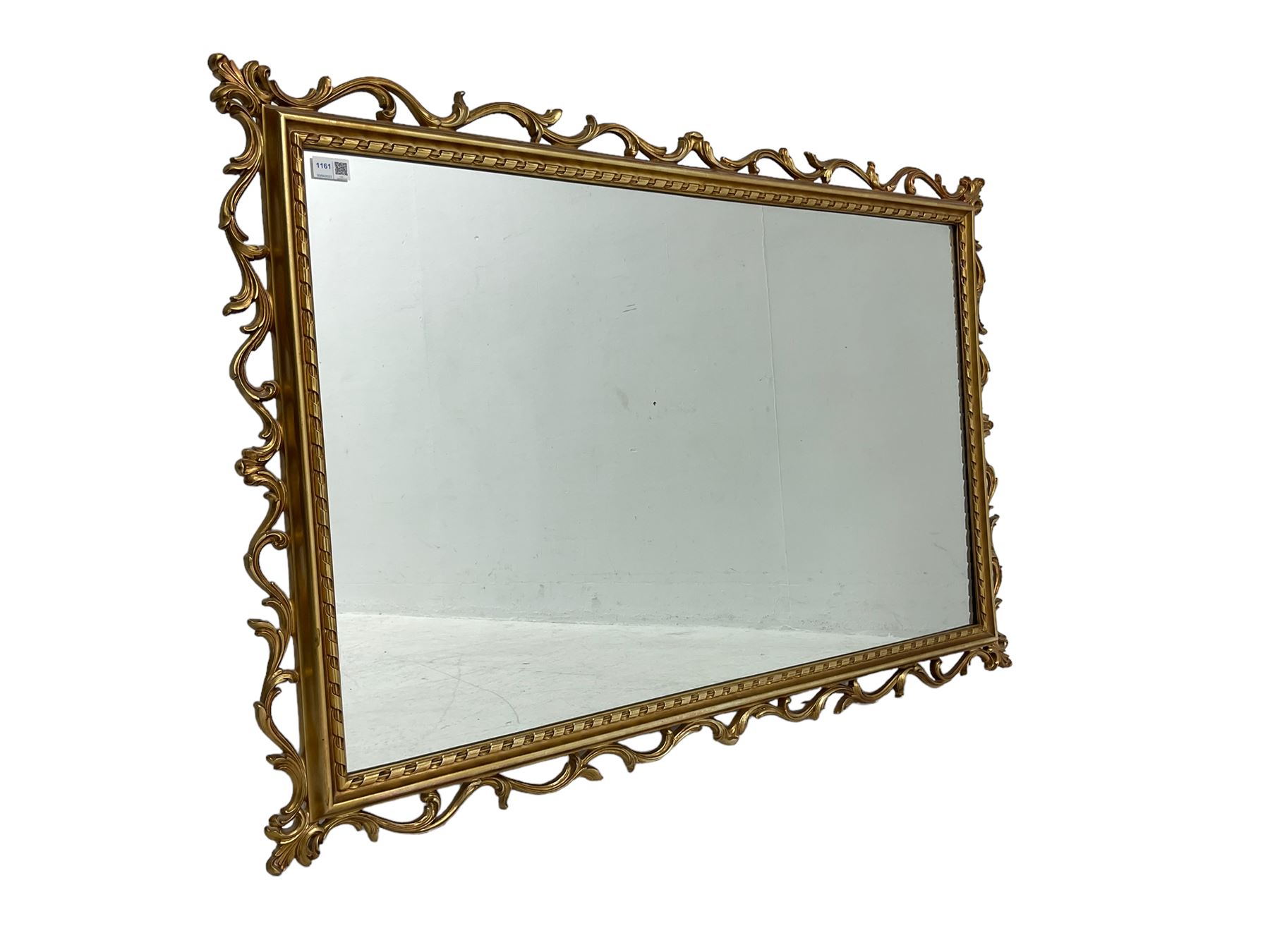 Ornate gilt framed mirror, decorated with trailing and scrolled foliage, plain mirror plate