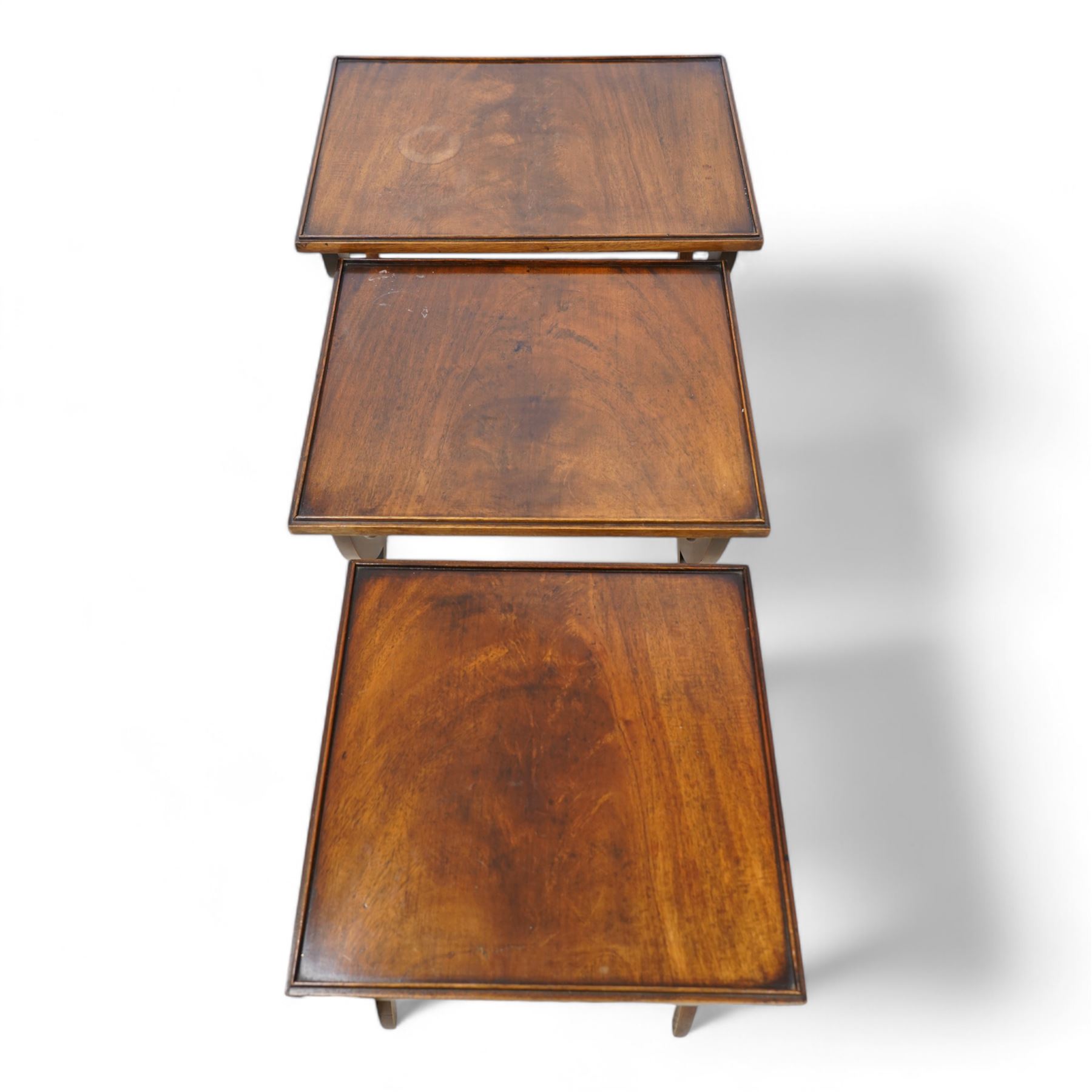 Regency design mahogany nest of three tables, rectangular top with raised lip on curved X-frame supports united by turned stretchers 