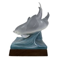 Tony Morris for Poole Pottery, leaping dolphin group, modelled over waves and mounted on a wooden base, H29cm. This model is a duplicate of a sculpture presented to Queen Elizabeth II and the Duke of Edinburgh on their visit to Poole Pottery in 1979, the original cast was destroyed after the production of the duplicate. Provenance: Arnold Smith, Chairman of Pool Potteries Collection