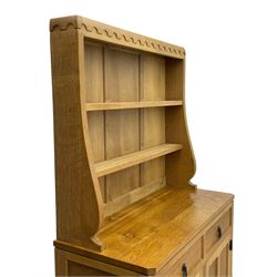 Mouseman - oak dresser, penny moulded cresting rail over two shelves supported by shaped ends, canted rectangular adzed top, fitted with two drawers and panelled cupboards, with wrought iron hinges and catches, on octagonal feet, carved with mouse signature, by the workshop of Robert Thompson, Kilburn 