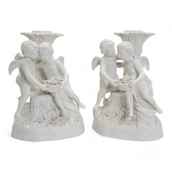 Pair of white porcelain candlesticks, originally candelabra, modelled as two cherubs holding a woven basket of flowers, perched before a tree trunk, possibly by Montreuil-sous-Bois, double crossed swords mark beneath and incised no. 1533, H23cm x W16.5cm 