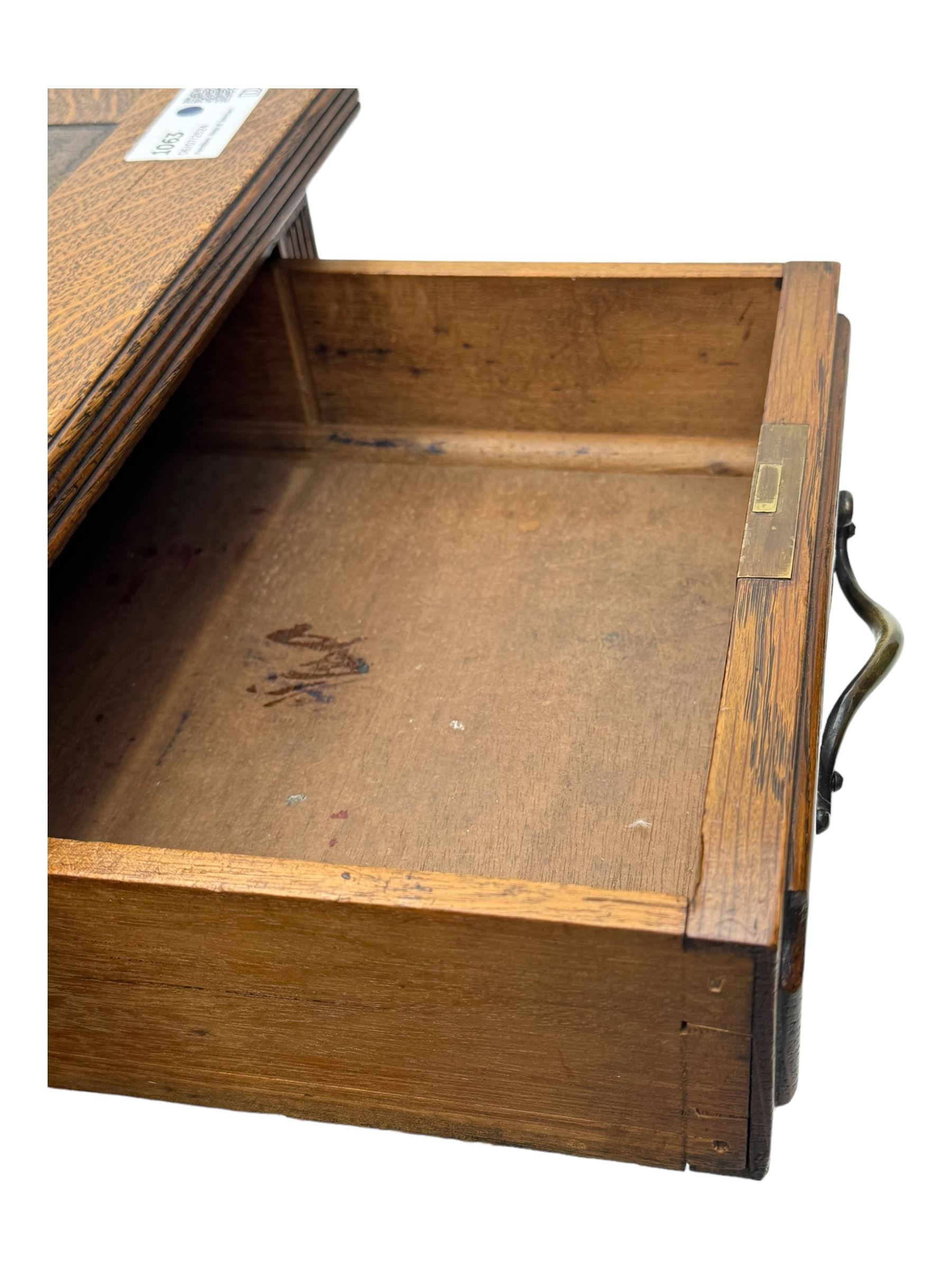 20th century oak twin pedestal desk, rectangular top with inset leather writing surface, fitted with nine drawers with chamfered edges to the raised panels, each with curved brass handles with scroll ends and keyholes, fluted detailing to the top and between the drawers, on moulded plinth base with castors