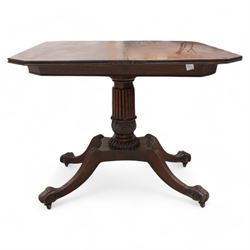 Regency mahogany card table, rectangular swivel and fold-over top with canted corners and reed-moulded edge, raised on a reeded pedestal with acanthus carved terminal and gardrooned collar, the concave rectangular base terminating to splayed supports with large paw feet on castors