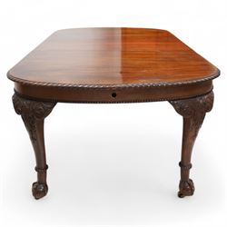 Early 20th century telescopic extending dining table, gardroon carved rectangular top with rounded ends, scrolled acanthus leaf carved cabriole supports with ball and claw feet, on brass castors, with two additional leaves  