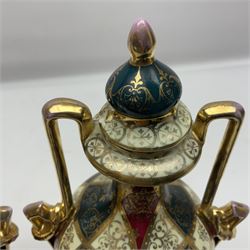 Pair of Vienna style twin handled urns and covers, decorated with figural scene on green, red and white ground with gilt highlights, stamped with beehive mark beneath, H25cm