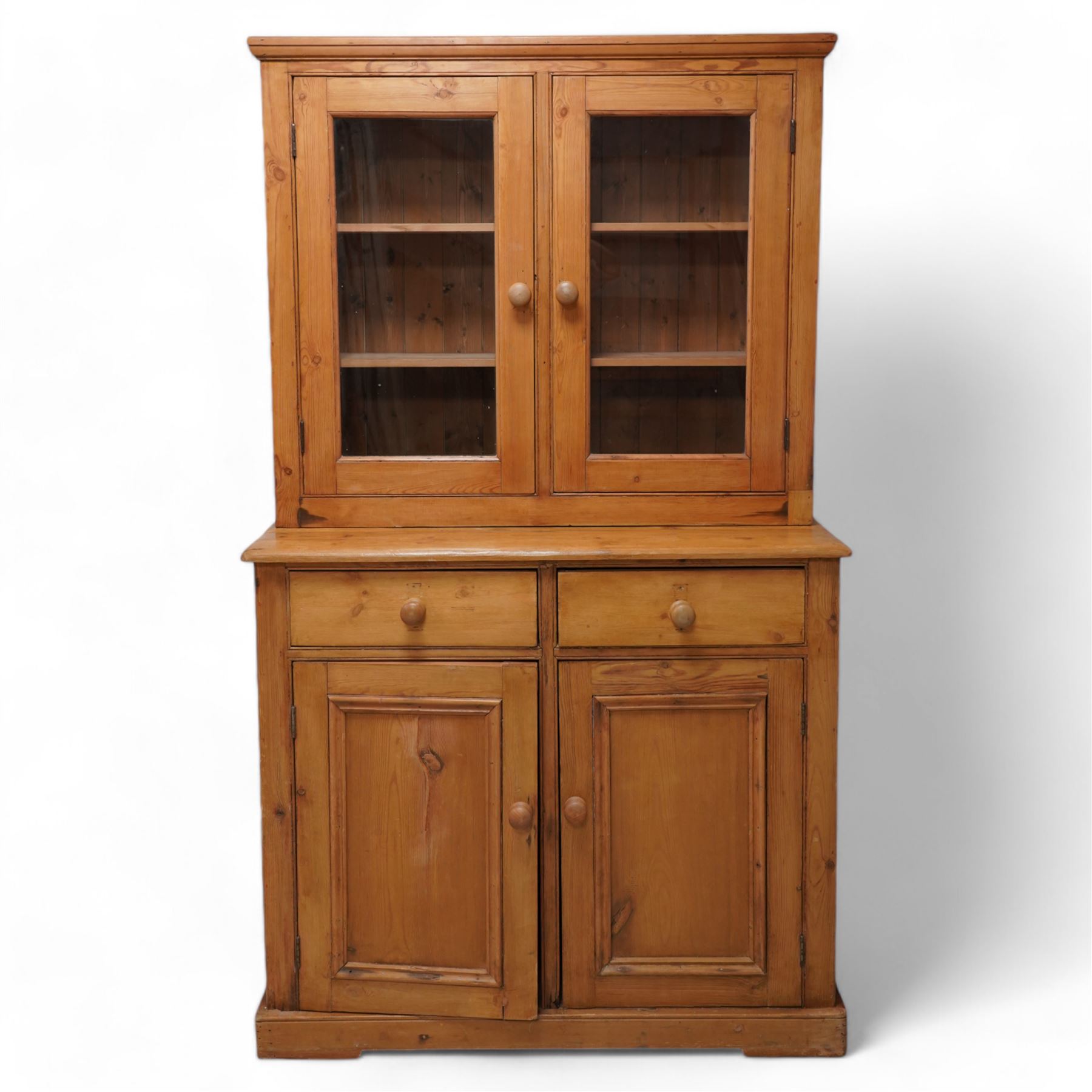 Late 20th century waxed pine dresser, raised display cabinet enclosed by two glazed doors, the base fitted with two drawers over panelled cupboard, on plinth base