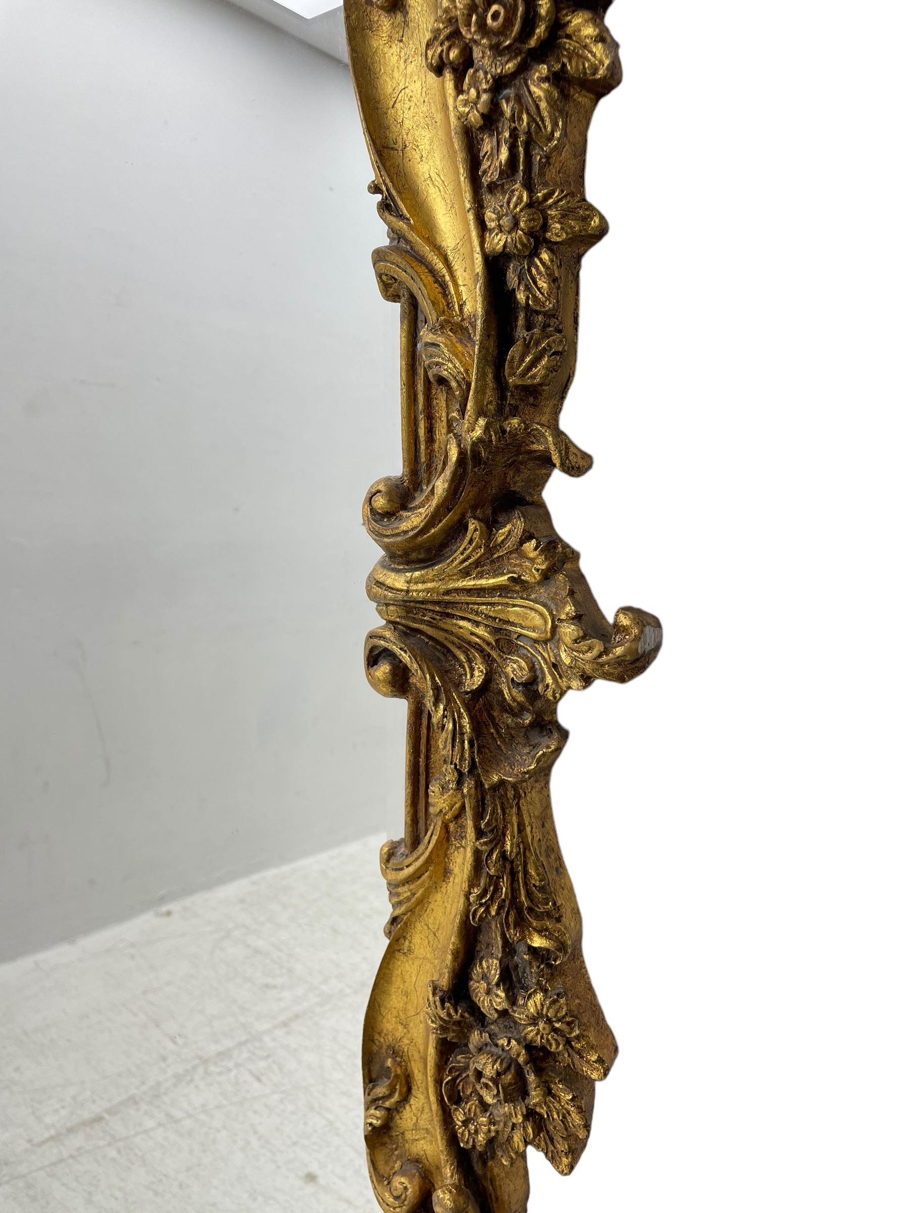 Large gilt framed rectangular wall mirror, shaped and moulded frame decorated with trailing curled acanthus leaves and flower head motifs, bevelled glass plate 