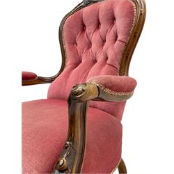 Victorian carved walnut open armchair, foliate carved cresting rail over butted back and sprung seat, upholstered in pink velvet scrolled arm terminals with moulded scrolling vines terminating to cabriole supports and ceramic castors