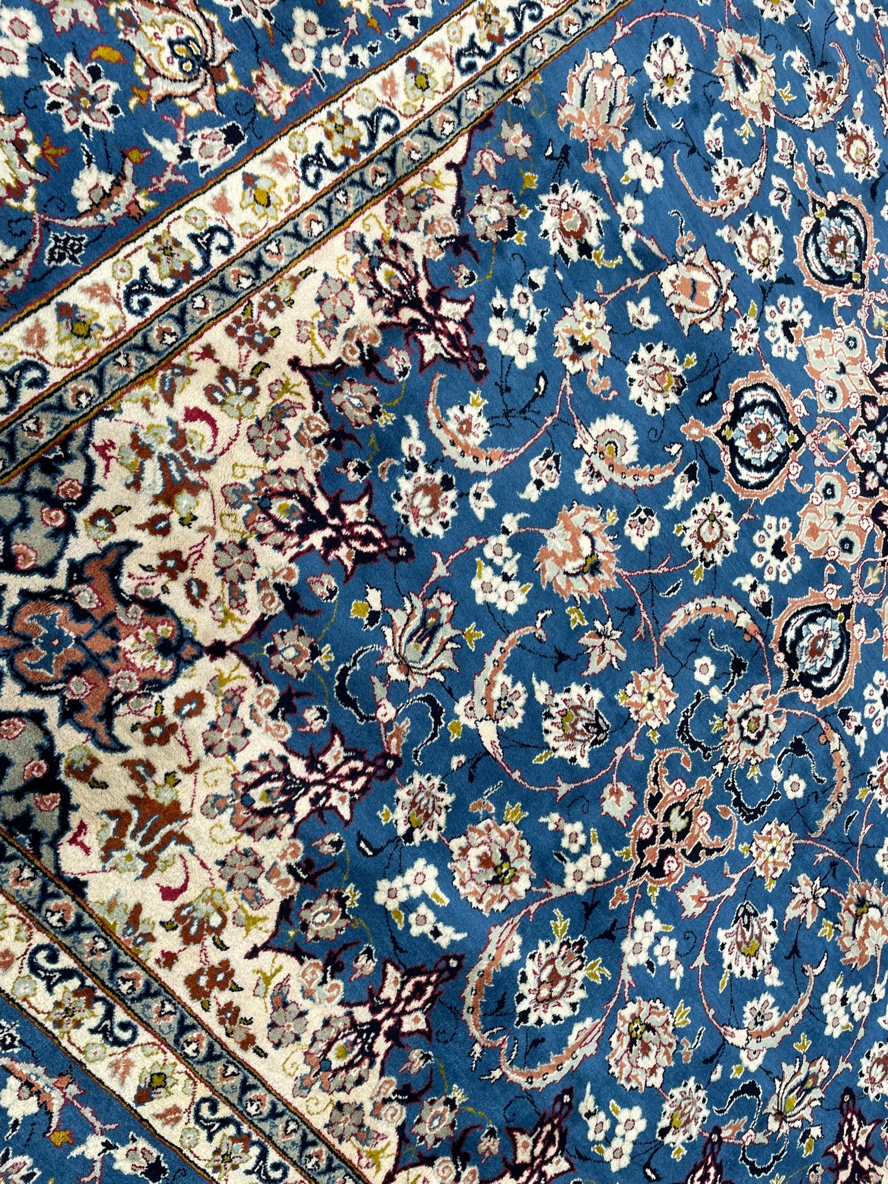 Persian Nain blue ground carpet, overall arabesque design, centre rosette medallion with eight projecting palmettes, the surrounding field decorated with interlacing branches and stylised plant motifs, within floral pale ground spandrels, the guarded border decorated with repeating stylised floral pattern 