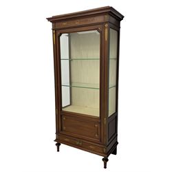 Early 20th century Louis XVI design mahogany vitrine display cabinet, projecting stepped cornice over recessed frieze decorated with gilt metal mounts of festoons and a bellflower wreath, fabric lined interior with two glass shelves, enclosed by bevel glazed door with lower panel, on two turned front feet 