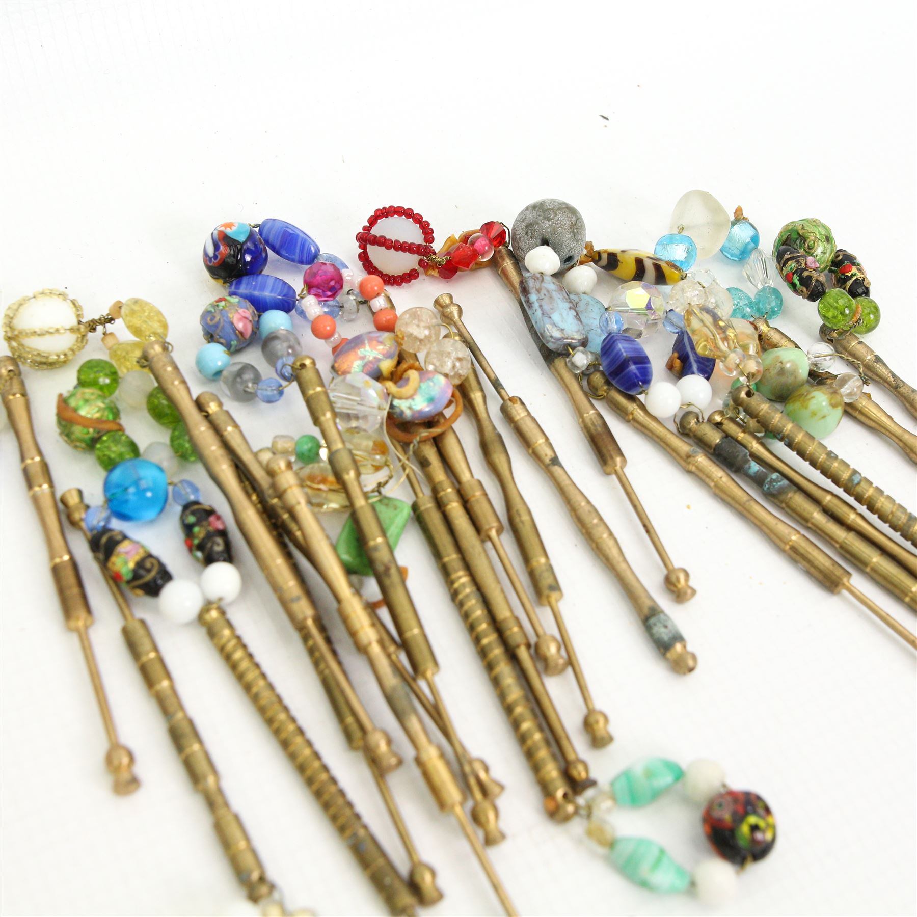 Collection of lace maker's bobbins to include ornate coloured glass examples, eight Maltese wooden bobbins, twenty brass bobbins with turned and textured shafts, together with various wooden examples, some with ornate glass beaded weights/ spangles 