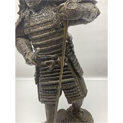 Bronze figure of a samurai standing wearing armour and holding a naginata, upon a rocky base, H48cm