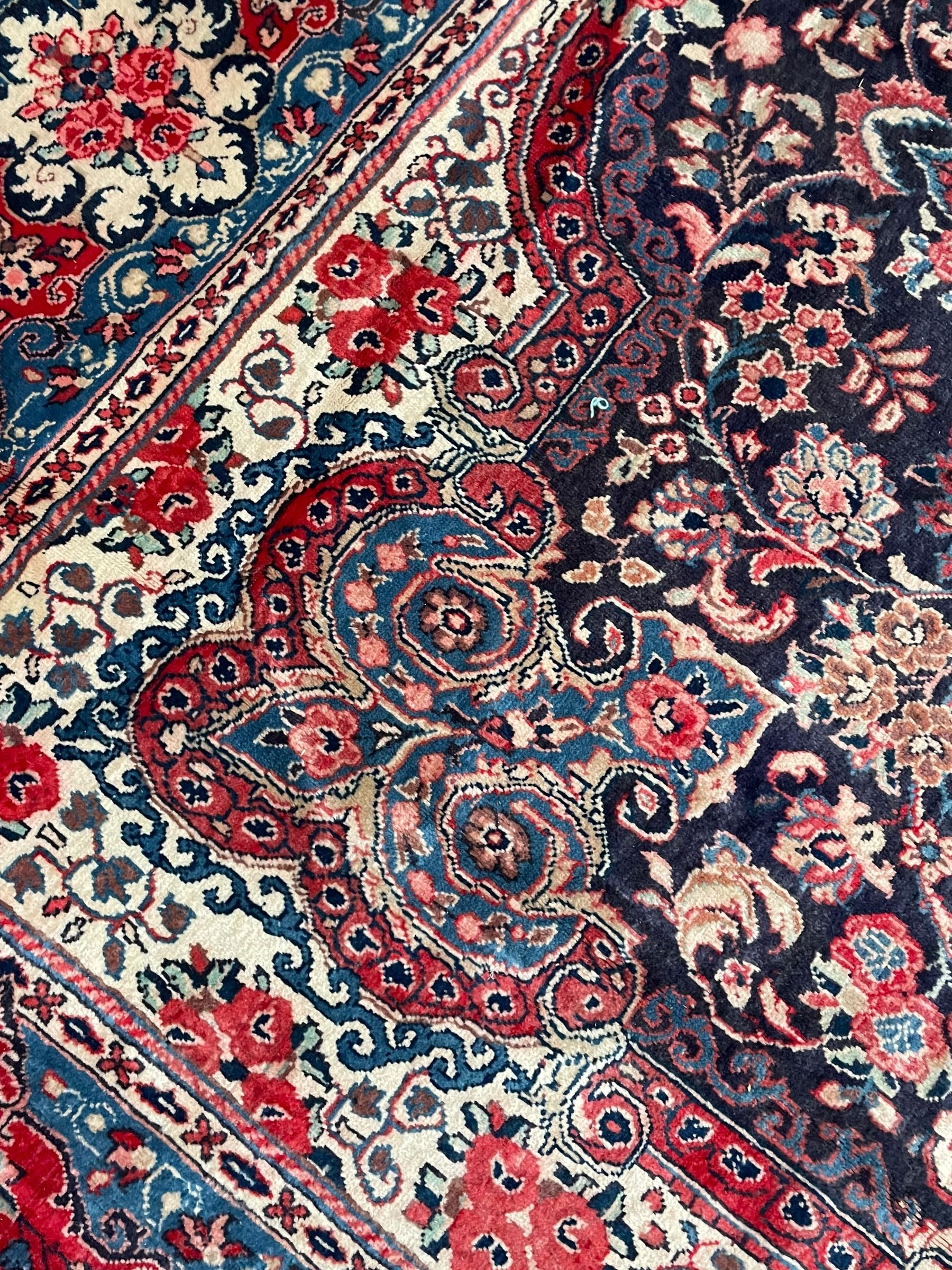 Persian Mahal indigo ground carpet, floral medallion on a field of swirling leafy branches and flower heads, shaped ivory field band decorated with flower head bouquets and trailing branches, the border decorated with floral motifs, within guard stripes