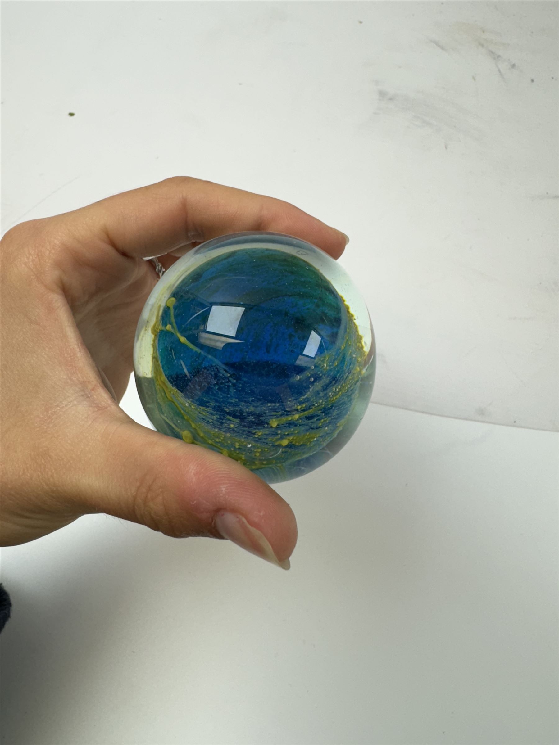 Two glass dump paperweights, with flower inclusions, together with four further glass paperweights